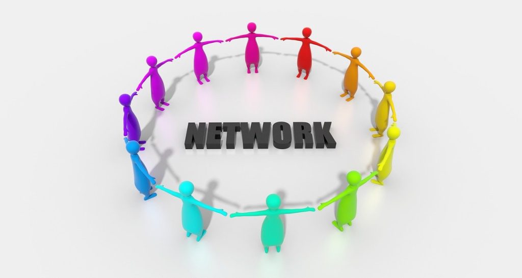 Abb. Wort "Network" wird von bunten Figuren die sich an den Händen halten umkreist 